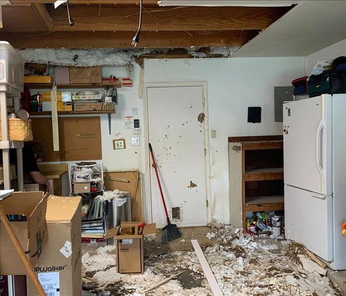 Room with debris on floor and a damaged ceiling
